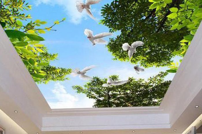 Alternative text: "A living room featuring a stretch ceiling printed with a scenic landscape of sky, trees, and a dove. The ceiling adds a touch of natural beauty, creating a serene and peaceful atmosphere in the room."